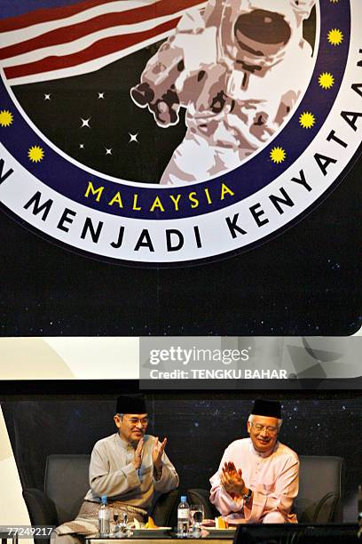 Malaysian Prime Minister Abdullah Ahmad Badawi and Deputy Prime Minister Najib Razak applaud as they watch a live telecast during the liftoff of a...