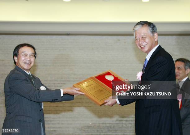 Japanese electronics giant Sony's financial unit Sony Financial Holdings president Teruhisa Tokunaka receives a wooden hammer from Tokyo Stock...