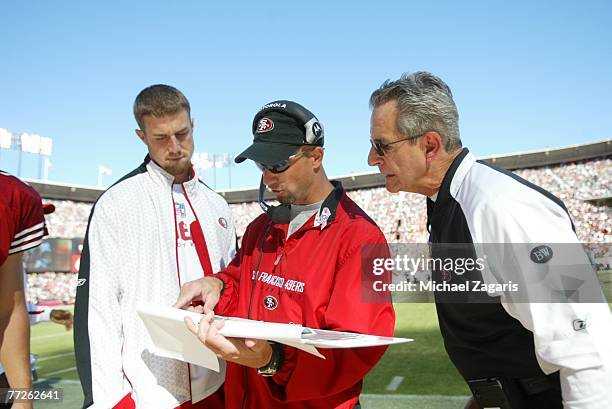 Jim Hostler meets with Alex Smith and Jerry Sullivan of the San Francisco 49ers during the NFL game against the Baltimore Ravens at Monster Park on...