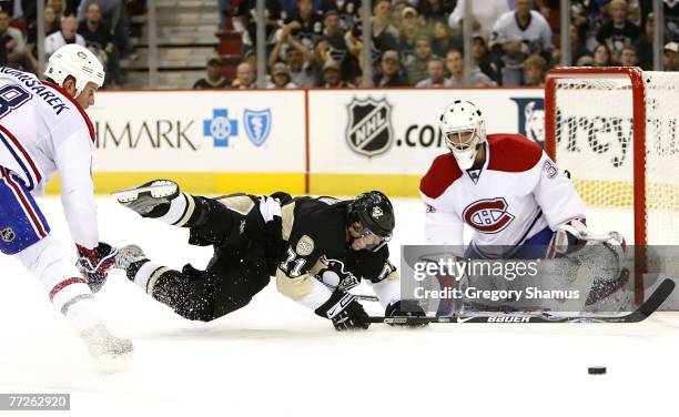 Evgeni Malkin of the Pittsburgh Penguins is taken down driving to the net between Michael Komisarek and Carey Price of the Montreal Canadiens on...