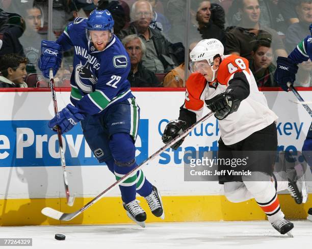 Daniel Sedin of the Vancouver Canucks and Daniel Briere of the Philadelphia Flyers battle for the puck during their game at General Motors Place on...