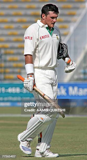 South African cricket captain Graeme Smith raises his bat as he leaves the ground after his dismissal during the fourth day of the second Test match...