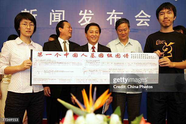 Wang Wei , Li Yingrui and other staff members of Shenzhen Huada Genetic Research Center, display the world's first diagram on the genome sequences of...