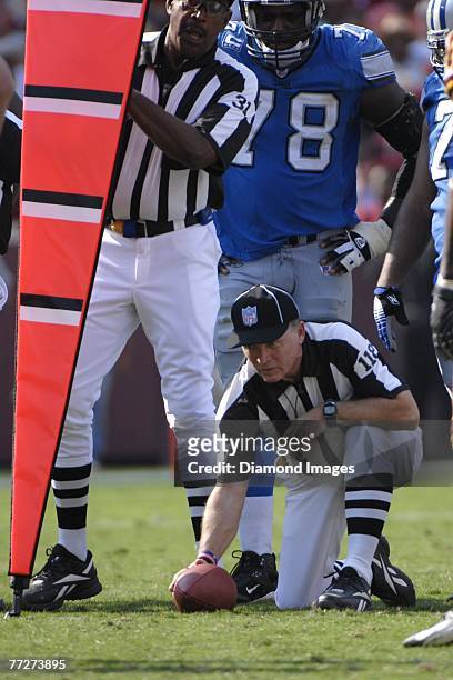 Field judge Tom Sifferman holds the ball at the line of scrimmage as the chain crew sets up to check to see if a first down was reached during the...