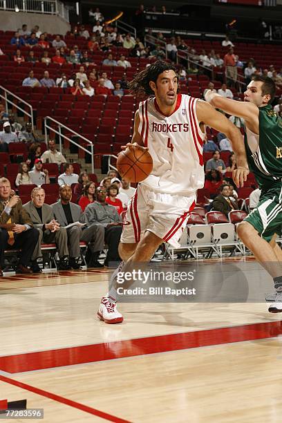 Luis Scola of the Houston Rockets drives past Dimitrios Diamantidis of Euroleague champion Panathinaikos October 11, 2007 at the Toyota Center in...