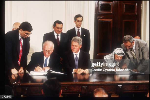 Celebrating the Israeli-Palestinian peace accord signed earlier in the week, President Bill Clinton sits with Yitzhak Rabin on his right and Yasser...