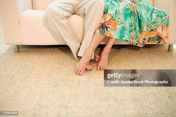 couple's feet in living room - playing footsie stock pictures, royalty-free photos & images