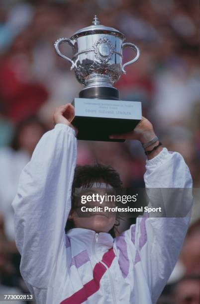 Spanish tennis player Arantxa Sanchez Vicario holds aloft the trophy after defeating German tennis player Steffi Graf 7-6, 3-6, 7-5 to win the...