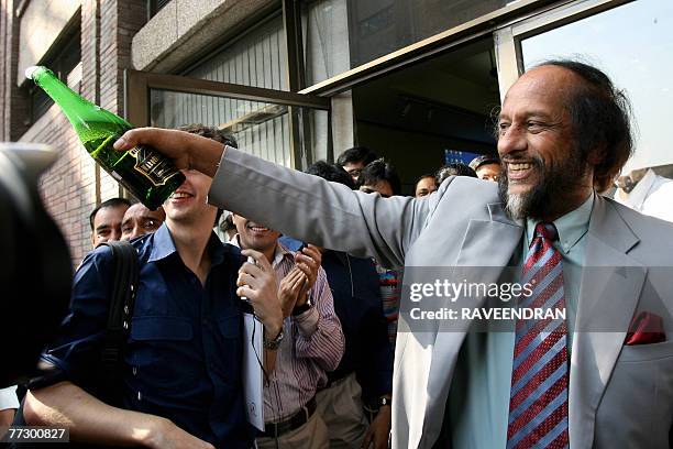 Chairman of the Intergovernmental Panel on Climate Change Rajendra Pachauri waves a champagne bottle after winning the Nobel Peace Prize in New...