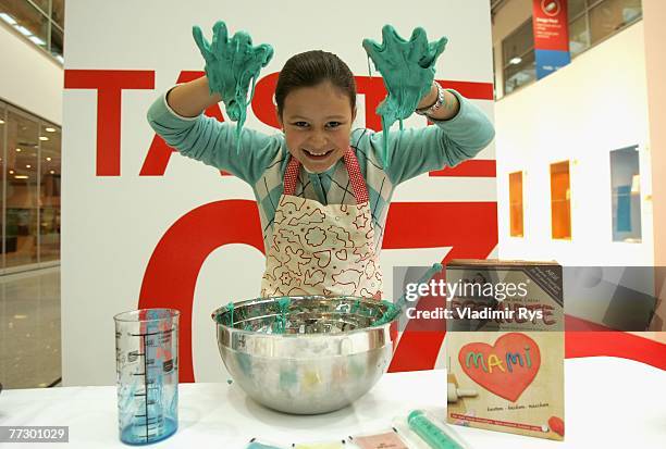 Young model with a colour dough on her hands poses for a photo during a photocall prior to the opening of the Anuga trade fair for the world of food...