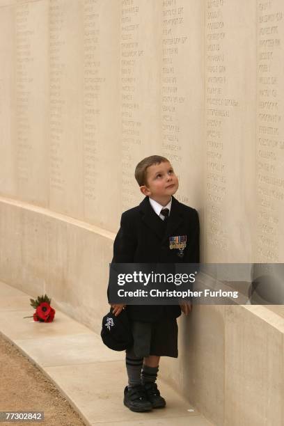 Five-year-old Alex Wall, of Norfolk, proudly wears his fathers medals as he searches for his father's name on the wall of the Armed Forces Memorial...