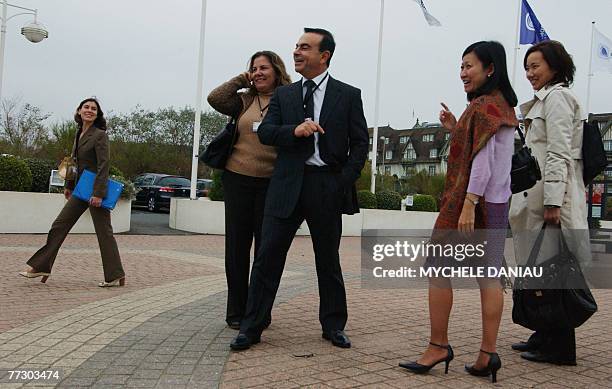 Renault and Nissan President Carlos Ghosn is surrounded by unidentified participants upon his arrival with his wife Rita at the Deauville...