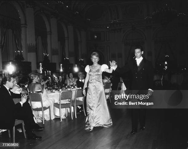 Attendees smoke and clap as an unidentifed man escorts a woman in an embroidered satin dress across the floor at the Italian Renaissance Ball held as...