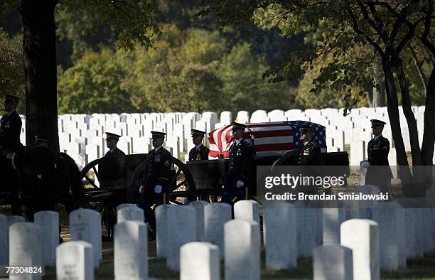 Casket containing the remains of soldiers who died in a helicopter crash earlier this year is brought to a grave site during a group burial at...