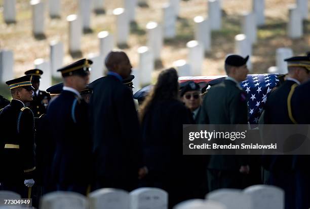 Casket containing the remains of soldiers who died in a helicopter crash earlier this year is brought to a grave site during a group burial at...