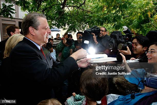 Former U.S. Vice president Al Gore signs a book as he leaves the offices of Alliance for Climate Protection after speaking to reporters during a news...