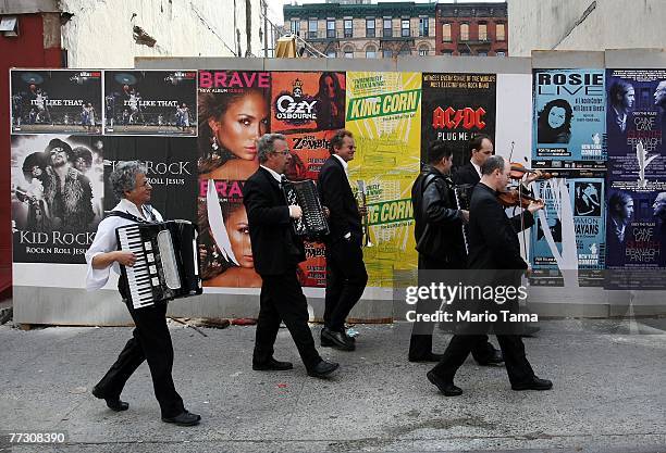 Klezmer musicians march through the Lower East Side after posing for a photo on the steps of the National Historic Landmark Eldridge Street Synagogue...