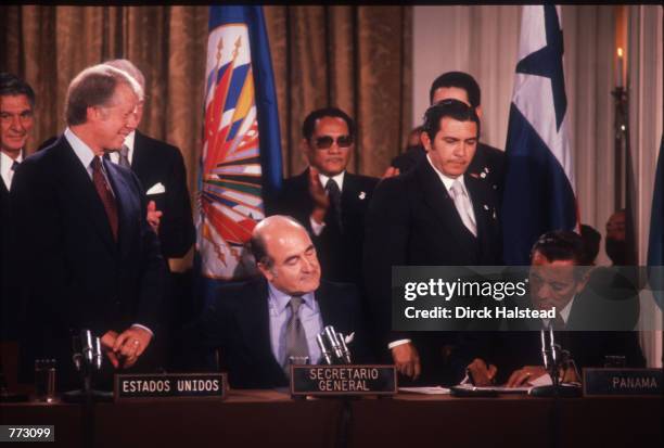 President Carter stands as Panamanian leader General Omar Torrijos Herrera signs at the OAS Headquarters September 7, 1977 in Washington, D.C. The...