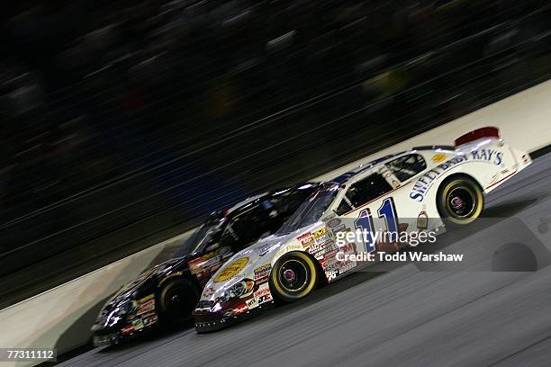 Yeley, driver of the Miccosukee Resorts Chevrolet, races Jason Keller, driver of the Sweet Baby Ray's Barbeque Sauce Chevrolet, during the NASCAR...