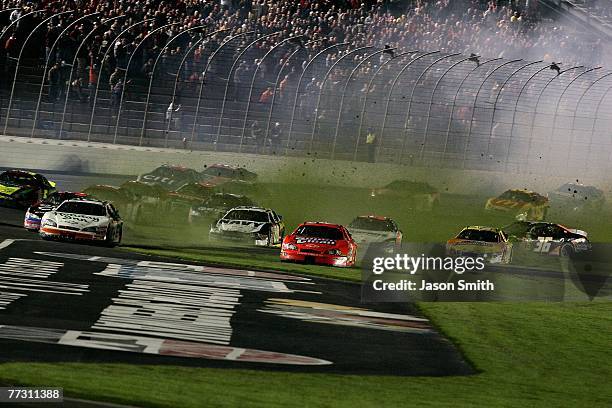 Cars drive off the track to avoid crashing during the NASCAR Busch Series Dollar General 300 at Lowe's Motor Speedway on October 12, 2007 in Concord,...