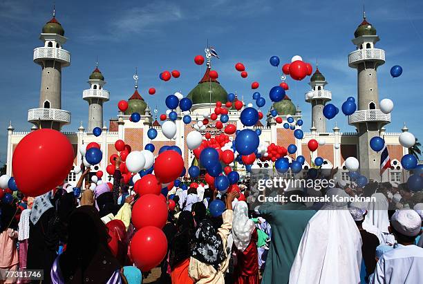 Thai Muslims release hundred of balloons after a morning prayer marking the start of the Islamic feast of Eid al-fitr outside Pattani mosque on...