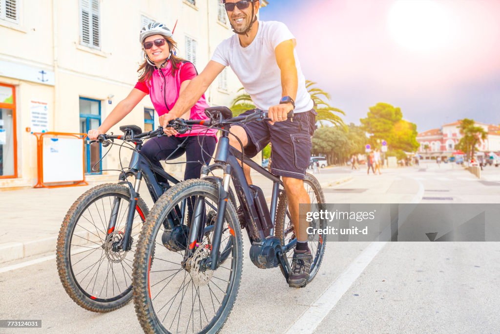 Couple Riding Bicycle On Road Against Sky