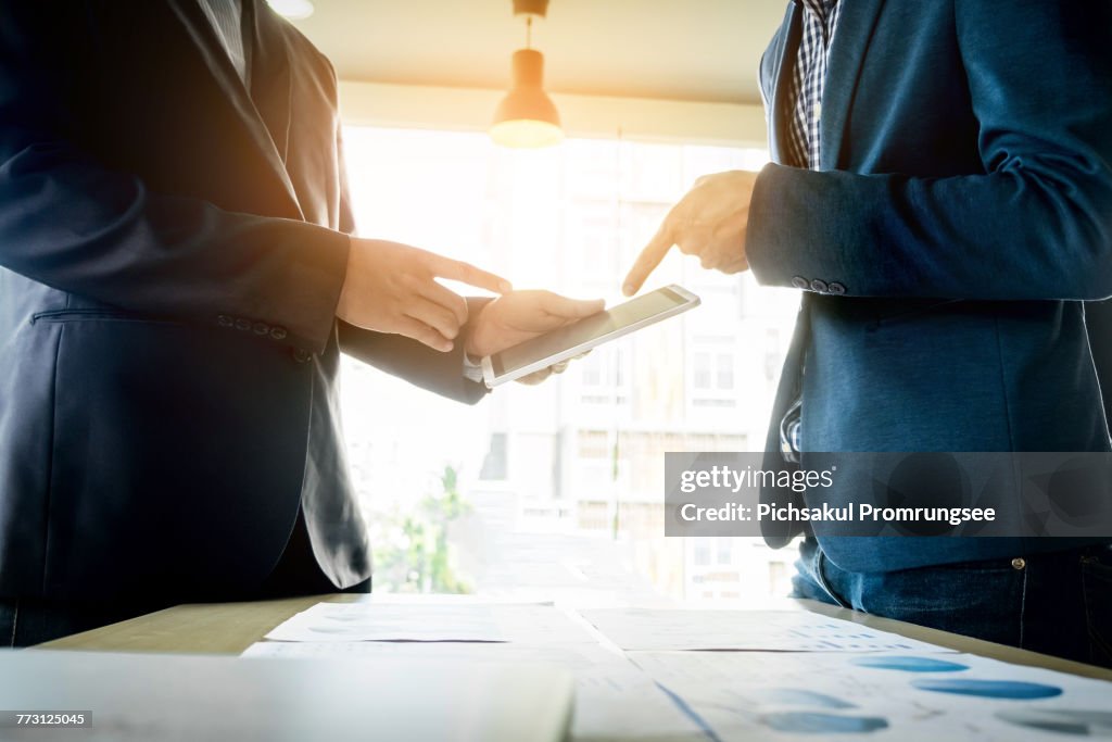 Midsection Of Businessmen Using Digital Tablet