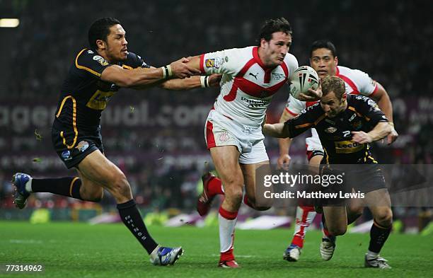 Lee Gilmour of St.Helens beats the tackle from Clinton Toopi and Rob Burrows of Leeds during the engage Super League Grand Final match between...