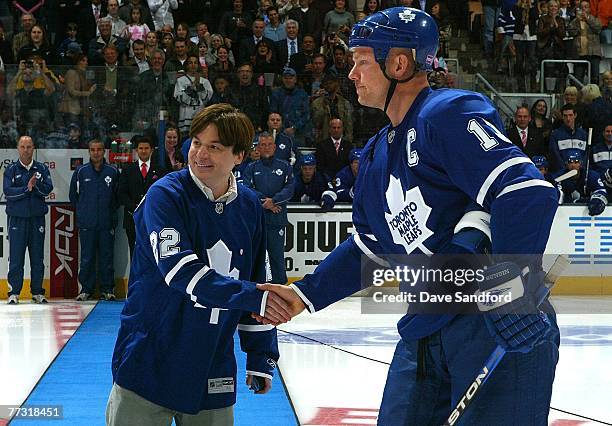 Mats Sundin of the Toronto Maple Leafs shakes hands with Mike Myers, who dropped the puck for the ceremonial face-off during their NHL game against...