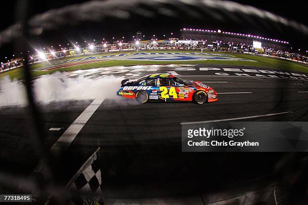 Jeff Gordon, driver of the DuPont Chevrolet, does a victory burnout after winning the NASCAR Nextel Cup Series Bank of America 500 at Lowe's Motor...
