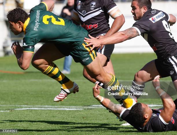 Israel Folau of the Kangaroos gets tackled by Dean Halatau of the Kiwis during the Centennial Test match between the New Zealand Kiwis and the...