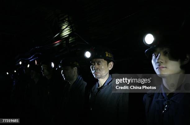 Workers attend a meeting about safety production in a pit at the Shihao Colliery on October 13, 2007 in Qijiang County of Chongqing Municipality,...