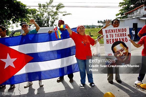 Cubans hold Cuban flags and posters of Hugo Chavez shortly after his arrival at the Santa Clara airport Ocotber 14, 2007 in Santa Clara, Cuba. Chavez...