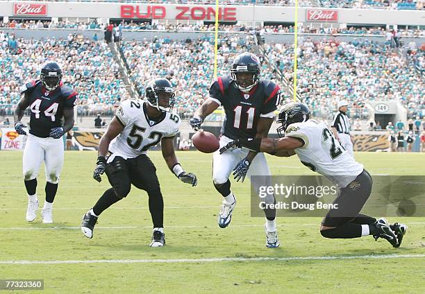 Wide receiver Andre Davis of the Houston Texans fumbles into the end-zone as he is hit by Sammy Knight and linebacker Daryl Smith of the Jacksonville...