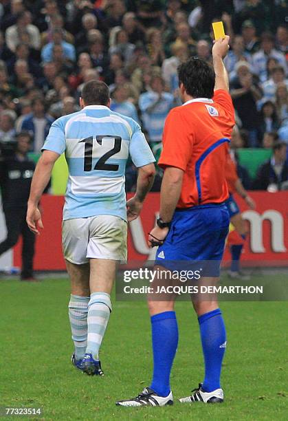 New Zealander referee Steve Walsh displays a yellow card to Argentina's centre Felipe Contepomi during the rugby union World Cup semi final match...