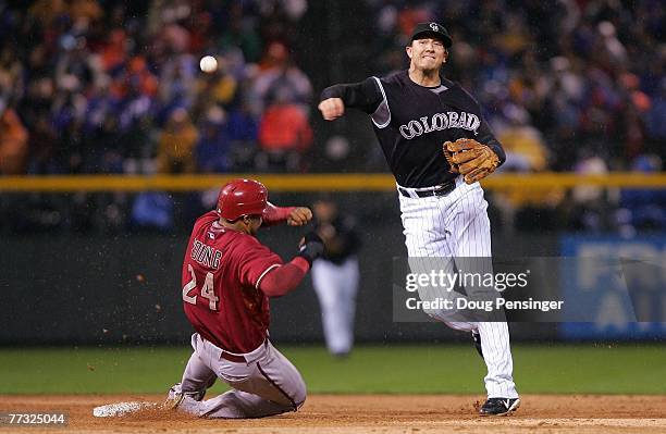 Troy Tulowitzki of the Colorado Rockies turns a successful double play over a sliding Chris Young of the Arizona Diamondbacks on a ball hit by...