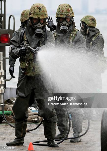 Members of Japan's Self-Defence Force exercise the removal of unidentified chemical substances with an anti-chemical suit during the Proliferation...