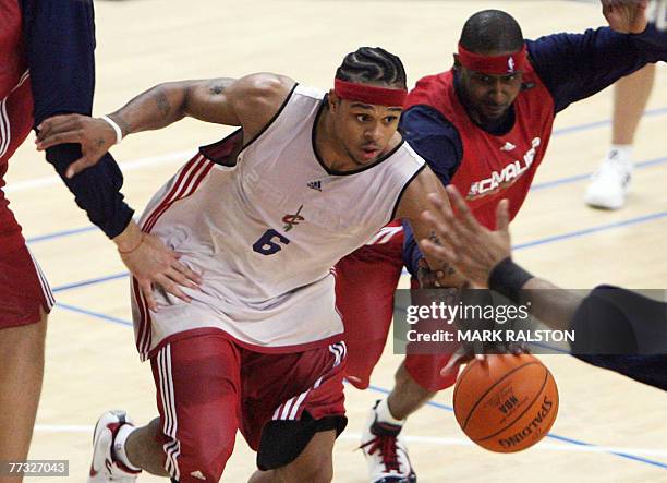 Player Shannon Brown of the Cleveland Cavaliers is chased by teammate Larry Hughes during a training session before their 17 October exhibition match...