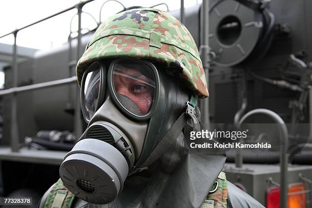 Member of Japan's Self-Defence Force exercise the removal of unidentified chemical substances with an anti-chemical suit during the Proliferation...