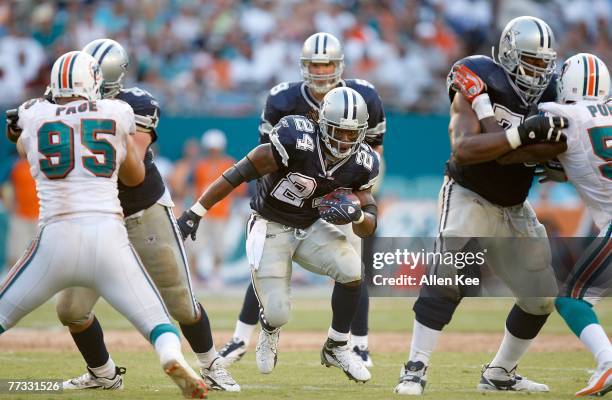 Running back Marion Barber of the Dallas Cowboys runs through a hole in the Miami Dolphins' defense at Dolphin Stadium on September 16, 2007 in...