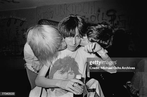 Patti Smith gets a kiss from Iggy Pop and James Williamson of The Stooges in November 1974 backstage at the Whisky a Go Go in Los Angeles California.