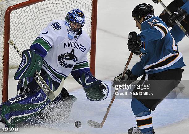 Goaltender Roberto Luongo of the Vancouver Canucks makes a save on Forward Jonathon Cheechoo of the San Jose Sharks during their game at General...