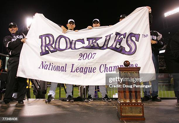 Members of the Colorado Rockies celebrate with a banner and the trophy after they won 6-4 against the Arizona Diamondbacks during Game Four of the...