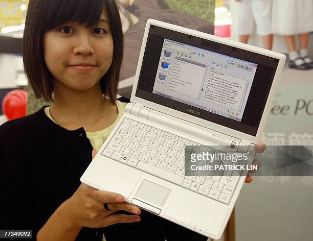 Woman staff of Asustek Computer Inc, a leading Taiwan computer maker displays a low-cost laptop computer after the company launches the model "Eee...