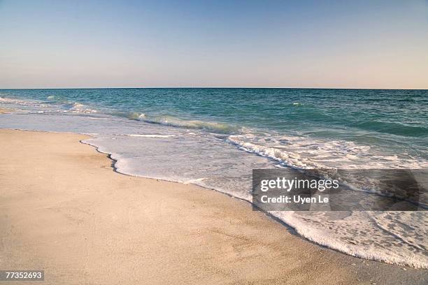 sand, sky, and water on a sarasota beach at sunset. - siesta key - fotografias e filmes do acervo