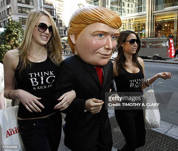 Models walk around with a mascot dressed as real estate developer Donald Trump before Trump arrives to promote his new book written with Bill Zanker,...