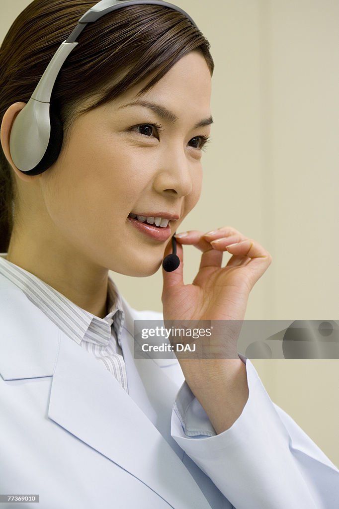 Female scientist wearing a headset, smiling, side view