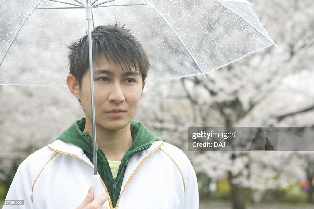 Portrait of a man holding an umbrella, front view, Japan
