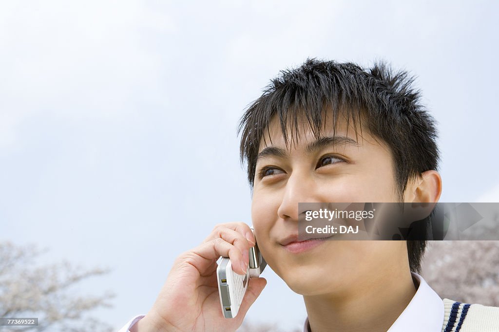 High School Boy Talking on Mobile Phone Under the Sky