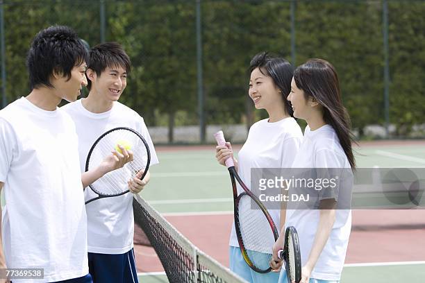 high school students on tennis court with holding tennis rackets - japanese tennis stock-fotos und bilder